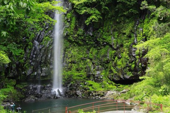 岩壁を落ちる八戸観音滝と手前の赤い手すり