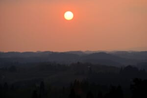 夕日に染まる山並みに沈む太陽