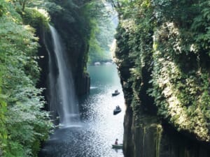 滝が落ちる高千穂峡の渓谷と貸しボート