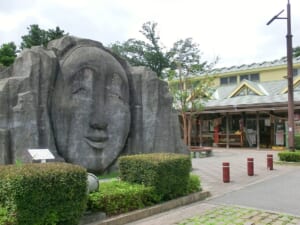大きな顔のモニュメントと道の駅高千穂の建物
